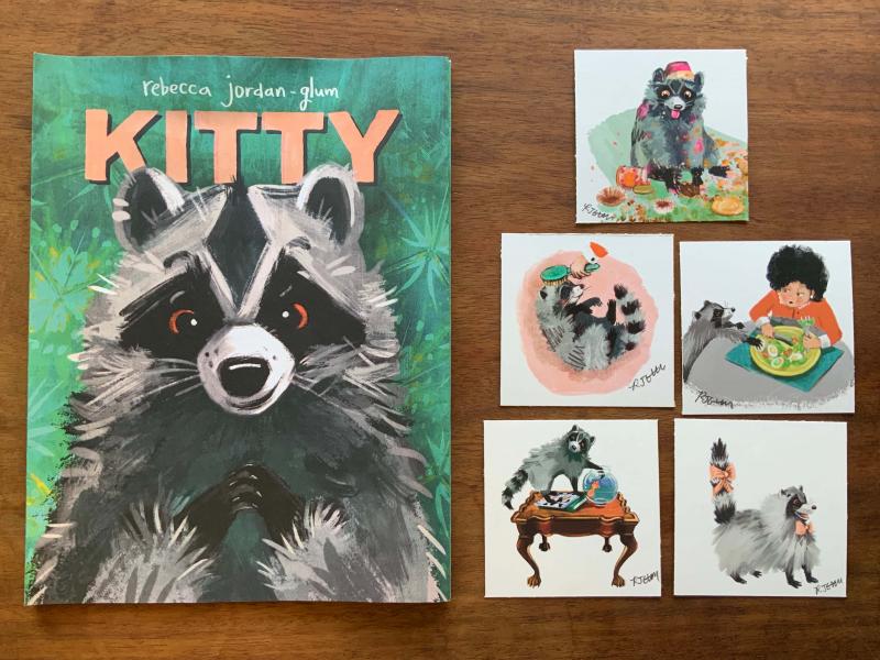 A copy of Kitty on the left hand side next to 5 different art prints. The prints are clockwise from top 1. Kitty raccoon making a large mess eating cupcakes  2. Kitty raccoon trying to steal an egg from Granny’s plate 3. Kitty raccoon freshly groomed with pink bows on its neck and tail 4. Kitty raccoon on ornate wood table trying to catch goldfish in fish bowl 5. Kitty raccoon enjoying being brushed by Granny