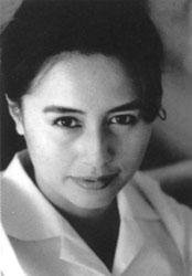LeUyen Pham photo. A black and white photo of an Asian woman with her hair up wearing a white collared, button up blouse. 