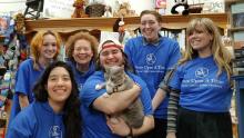 The Once Upon A Time Bookstore staff back rows Maddie, Maureen, and Iz. Front row is Jessica, Apollo holding Pippi, and Maddi. All wearing their blue Once Upon A Time hoodies or shirts.